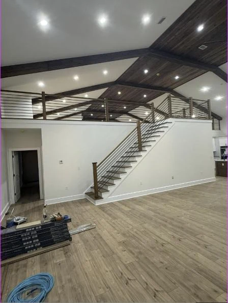 Great room with vaulted shiplap ceiling, timber beams, loft and cable rail staircase