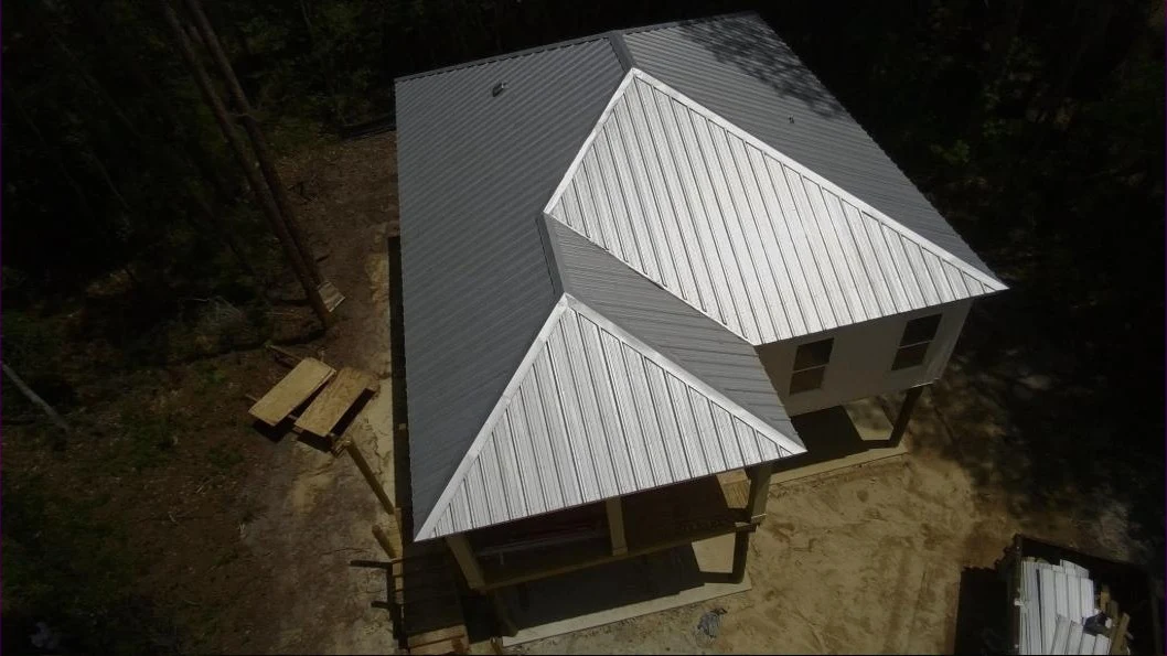 Aerial view of a newly installed grey and white standing seam metal roof