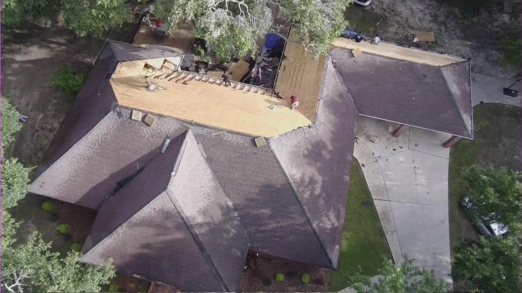 Aerial view of a roof stripped to bare decking during a Keller Built Construction roof replacement
